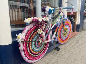 photo of a racing bike completely covered in multi-coloured crochet